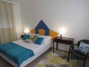 1 dormitorio con 1 cama con cabecero azul y amarillo en Arôme Marin, en Le Marin