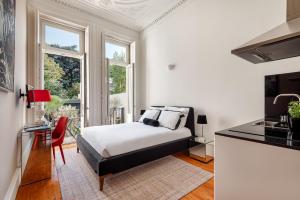 a bedroom with a white bed and white walls at Maison Cabral in Porto