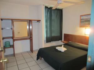 a bedroom with a black bed and a window at Hotel Vagabundo Puerto Vallarta in Puerto Vallarta