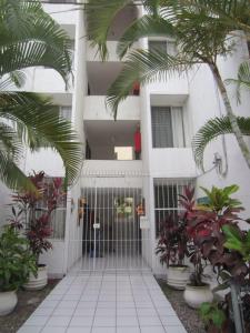 a white building with a gate and palm trees at Hotel Vagabundo Puerto Vallarta in Puerto Vallarta