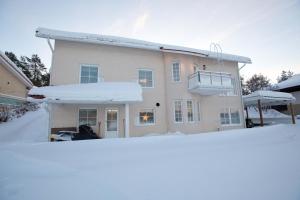 a house with snow in front of it at Villa Ranta in Rovaniemi