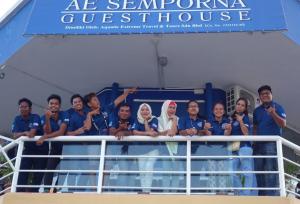 a group of people posing for a picture on a boat at AE Semporna Guesthouse 极潜旅店 in Semporna