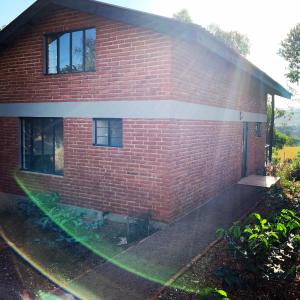 a red brick house with a rainbow in front of it at Lilac Hideaway in Karatu