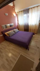 sypialnia z fioletowym łóżkiem i oknem w obiekcie Studio Mali Jadran w Splicie