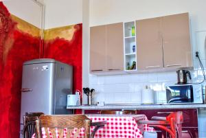 a kitchen with a refrigerator and a table and chairs at Hostel PanGeea in Sibiu