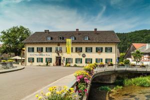 a bridge over a river in front of a building at Hotel zum Bräu in Kinding