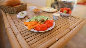 un plato de zanahorias y verduras en una mesa de madera en Negev Camel Ranch, en Dimona