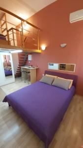 sypialnia z dużym fioletowym łóżkiem w pokoju w obiekcie Studio Mali Jadran w Splicie