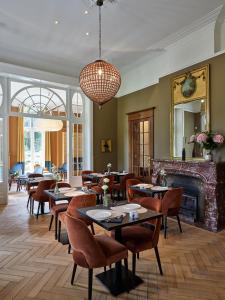 a restaurant with tables and chairs and a fireplace at Boutique Hotel Ter Wallen in Izegem