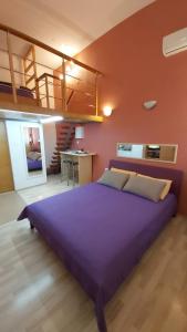 sypialnia z dużym fioletowym łóżkiem i schodami w obiekcie Studio Mali Jadran w Splicie
