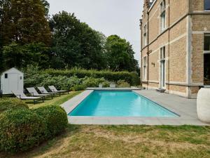 a swimming pool in a yard next to a building at Kasteel Ter Wallen - Boutique Hotel in Izegem +24 photos