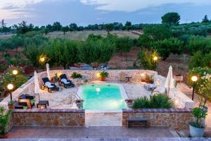 an outdoor swimming pool with a patio and lounge chairs and a resort at B&B Mandorla Amara in Gioia del Colle