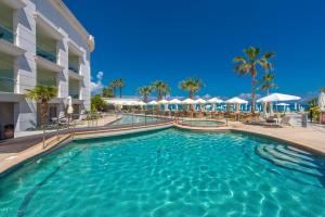 a swimming pool at a resort with palm trees and umbrellas at Elinotel Apolamare Hotel in Hanioti
