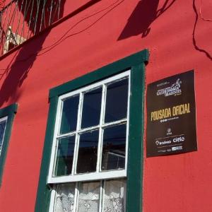 a red and green building with a window at Pousada Recanto de Minas - no Centro in Tiradentes