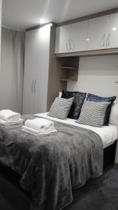 a bedroom with a large bed with towels on it at The Hatton Rooms in New Bedfont