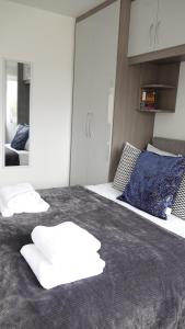 a bedroom with a large bed with two pillows on it at The Hatton Rooms in New Bedfont