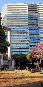 a tall building with a park in front of it at Pertim de Tudo in Belo Horizonte