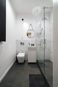 Un baño blanco con inodoro y lavabo. en Apartament Business, en Poznan