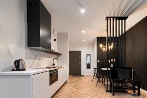 cocina con encimeras blancas y mesa con sillas en Apartament Business, en Poznan