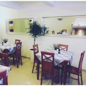 - une salle à manger avec des tables, des chaises et un miroir dans l'établissement Willa Potok, à Krynica-Zdrój