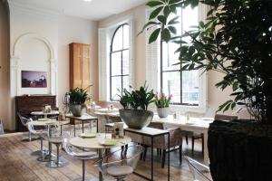 a restaurant with tables and chairs and potted plants at Suitehotel Pincoffs in Rotterdam