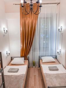 een slaapkamer met 2 bedden en een kroonluchter bij Hostel u Kmity in Krakau
