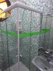 a bathroom with green arrows on a glass shower at Pousada Fonseca in Itanhaém +104 photos