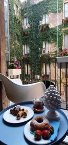 une table avec deux assiettes de nourriture au-dessus dans l'établissement Palazzo del Verga, à Catane