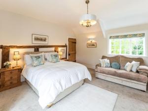 a bedroom with a large white bed and a couch at Pinley Hill House in Hatton