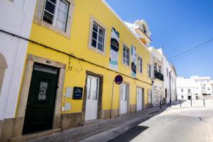 a yellow building on the side of a street at Faro Guest House in Faro