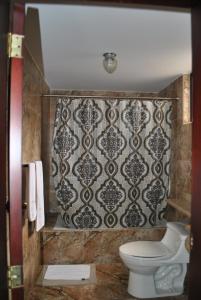 baño con aseo y pared en MAK INN HOUSE, en Latacunga