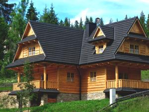 a large log cabin with a black roof at Domek na Kamieńcu in Witów