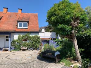 una casa con un árbol y un banco en un patio en Gaensebluemchen 1 Apartment daisy 1, en Walsdorf