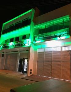 un bâtiment avec des lumières vertes au-dessus dans l'établissement POUSADA PONTAL DO AGRESTE, à Itabaiana