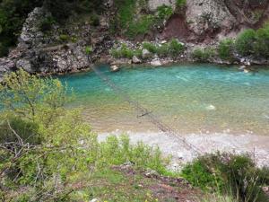 a river with blue water and rocks in a field at Athamania Artas in Athamanio
