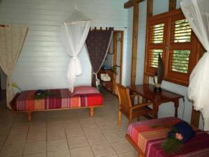 a bedroom with a bed and a table and a desk at Villa Mahogany in Deshaies