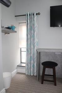 a bathroom with a toilet and a shower curtain at The Royal Hotel and Bar in Lancaster