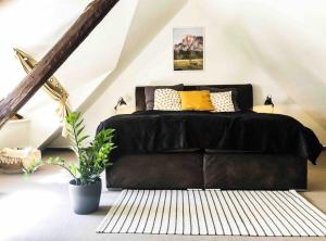 a bedroom with a black bed with yellow pillows at Maisonette am Markt - Schlossblick - WLAN+Netflix in Wernigerode
