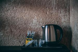 een koffiepot en glazen op een tafel bij Zeina Desert Lodge in Wadi Rum