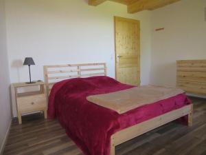 a bedroom with a large bed and a night stand at Gîte Potimarron in Ancelle