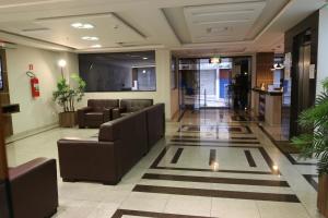 a lobby with couches and chairs in a building at Ouro Minas Plaza Hotel in Aparecida