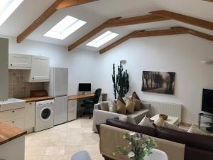 a living room with a couch and a kitchen with skylights at The Coach House in Cardiff
