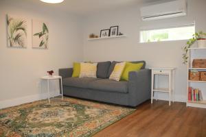 a living room with a gray couch and a rug at HiddenGem-private modern suite on trendy Main St in Vancouver