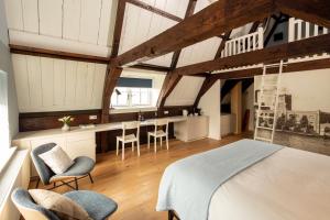 a bedroom with a bed and chairs in a room at Saenliefde in Wormer