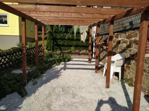 a wooden pergola with a white chair under it at Ferienwohnung Gönnern - Marburg Biedenkopf mit 5 Zimmer - 2 Badezimmer in Gönnern