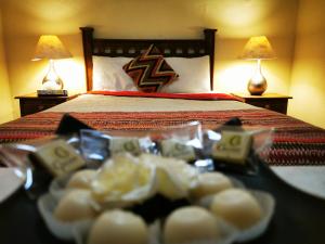 Habitación de hotel con cama y bandeja de comida en Hotel Chocolate Suites, en Guanajuato
