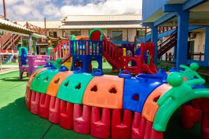 um parque infantil com equipamento de brincar colorido num quintal em Pousada Laguna Hotel em Cabo Frio