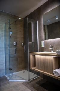 y baño con ducha y lavamanos. en Lignum Hotel en Miskolctapolca