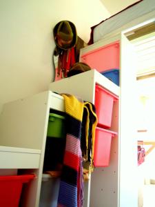 a closet with a white cabinet with colorful folders at MissOrtelia B&B in Amsterdam