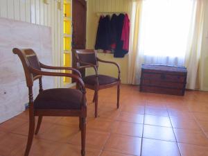a room with two chairs and a closet with clothes at La Casa del Viento in Talcahuano